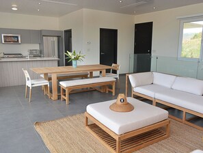 Eine moderne Küche mit Essbereich, einer Couch und Blick ins Freie.