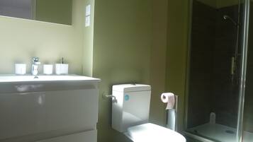 A bathroom with a toilet, sink, and shower.