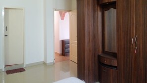 Un dormitorio con un armario de madera, una puerta y un pasillo visible.