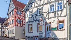 A traditional half-timbered building with a sign indicating a hotel and cafe. - Hotel am Markt (Hungen)