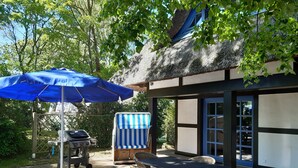 An outdoor patio with a table and chairs, a barbecue grill, and a blue umbrella. - Landhaus Szczecin Lagoon, house3 (Dargen)