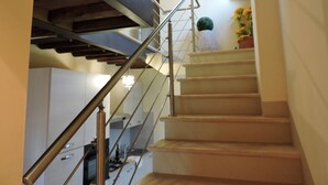 Eine Treppe mit Metallgeländer, die zu einer Zwischenebene führt.