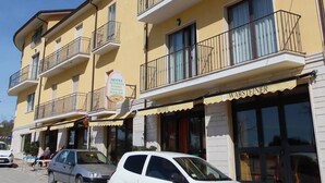 Un hotel de varios pisos con balcones, un letrero que indica que cuenta con restaurante, y una fachada visible con el letrero "WARSCHTENER".