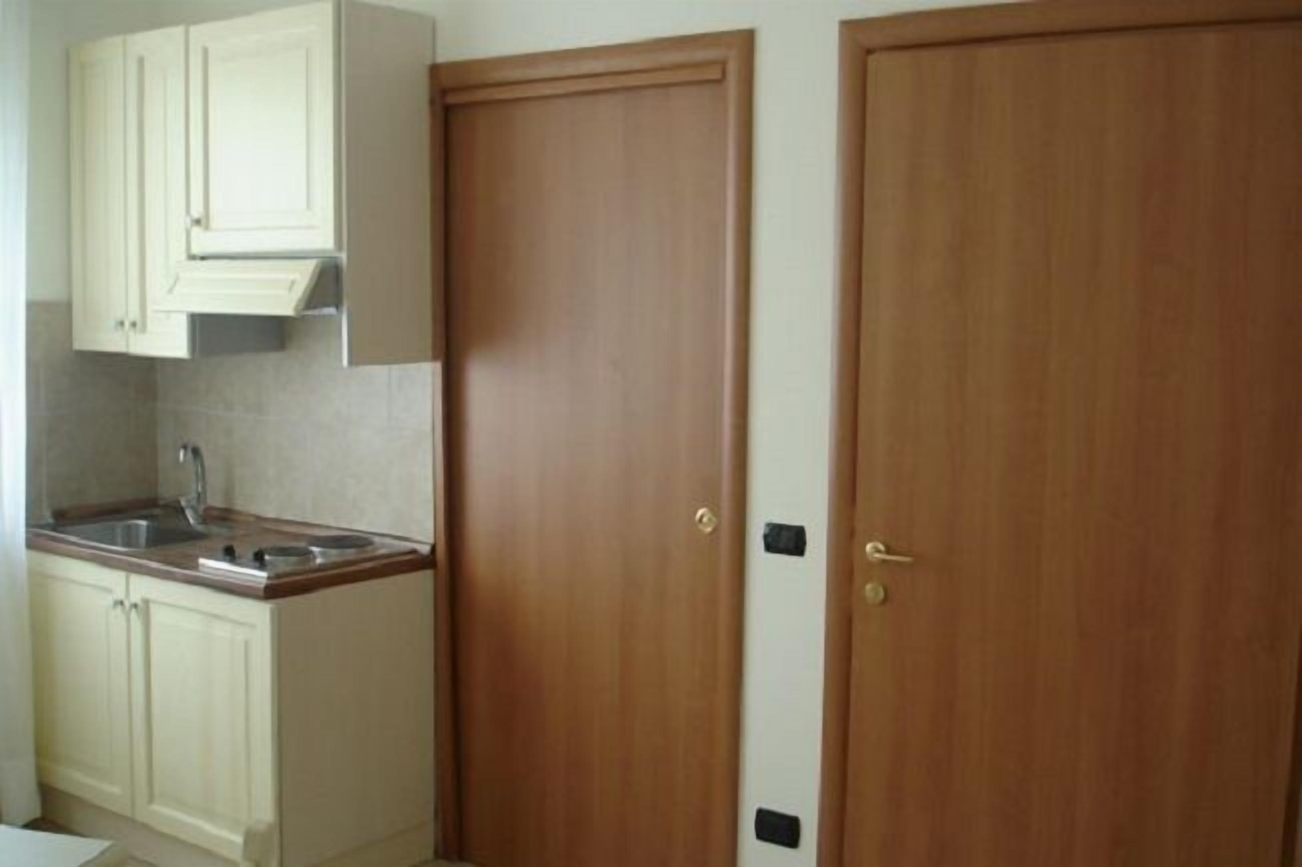 A kitchen with white cabinets, a sink, and a stove.