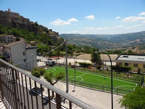 Vista di un campo sportivo con un edificio sullo sfondo.