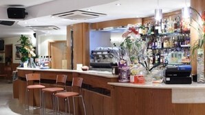 A bar area with wooden counters, bar stools, and a variety of bottles and snacks. - Coste Del Lago (Limosano)