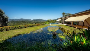 A modern hotel with a swimming pool surrounded by lush greenery and mountains in the background. - Casa Laureles (Bejuco)