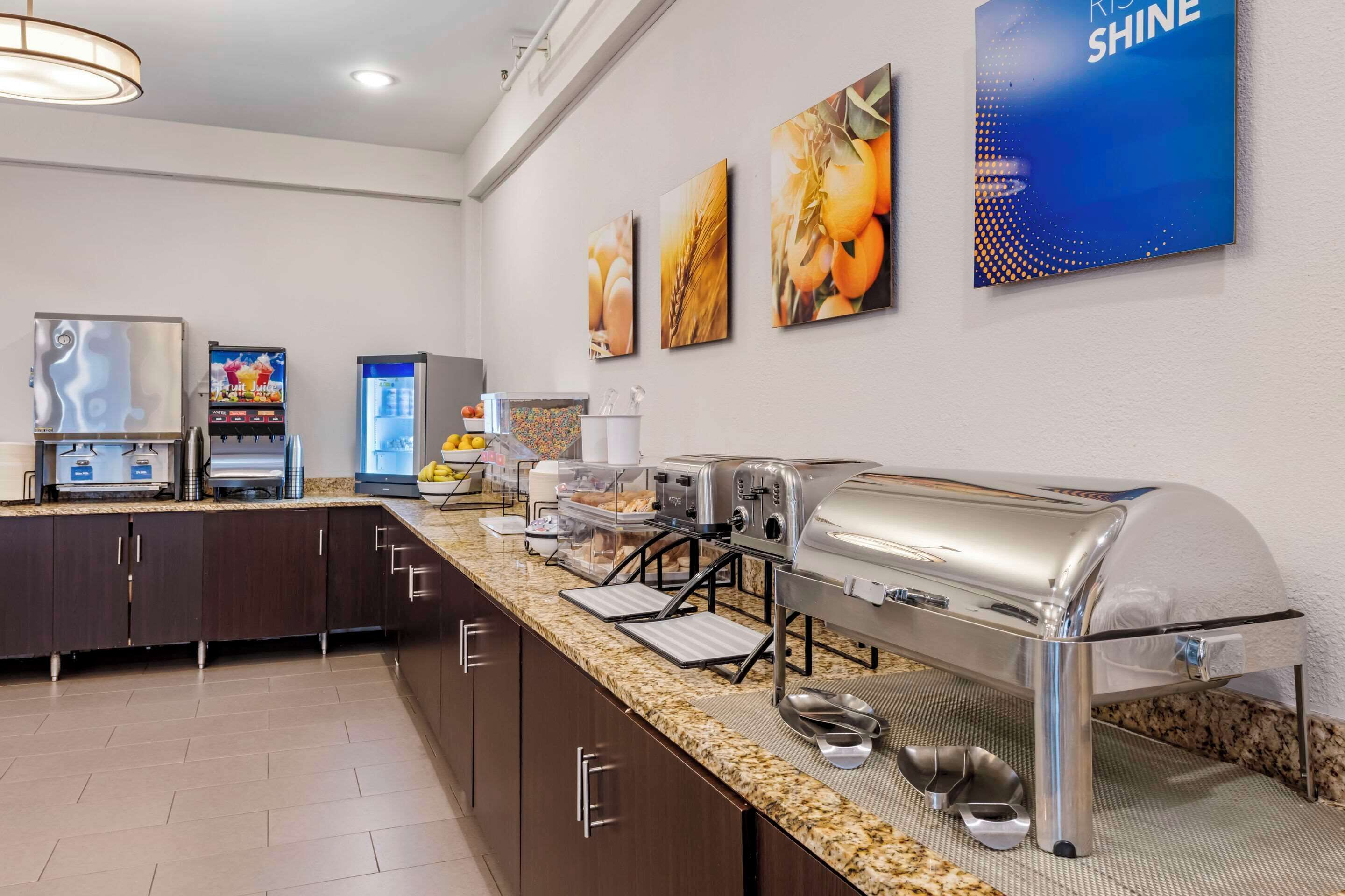 Un espace dédié au petit-déjeuner, aménagé avec un buffet comprenant un grill, des machines à café et un réfrigérateur.