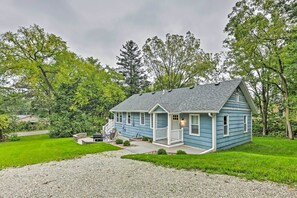 A single-story house with a porch, surrounded by a well-maintained lawn and trees.
