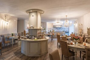 A spacious kitchen with a central island, modern appliances, and a chandelier.