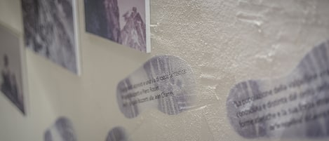 En vägg med tryckt text och bilder, inklusive ett bergslandskap och en persons siluett.