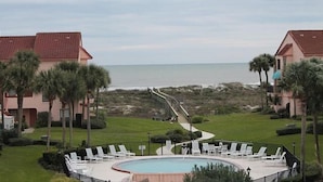 A pool area with lounge chairs, a view of the beach, and a pathway leading to the beach. - Sea Place 13239 (St. Augustine)