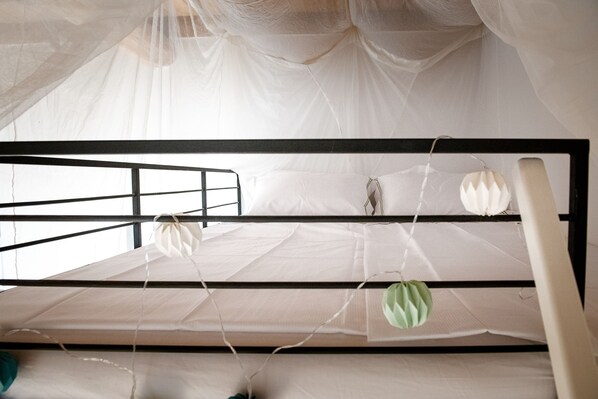 A bunk bed with a mosquito net overhead.