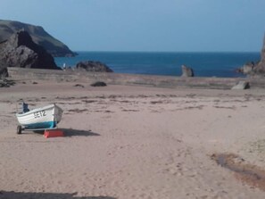 A beach with a small boat labeled 'SE12' on the sand.