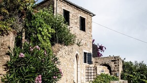 Un bâtiment en pierre avec un étroit sentier également en pierre menant à une porte.