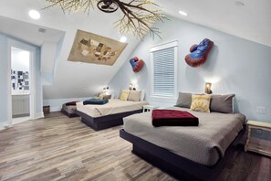 Ein modernes Schlafzimmer mit zwei Betten, einer geneigten Decke und einer Wanddekoration.