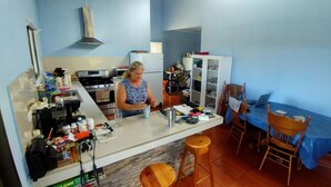 A compact kitchen with a stove, refrigerator, and a dining area with a table and chairs.