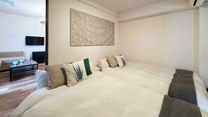 A modern bedroom with a large bed, a flat-screen TV, and a decorative wall piece. - 1 Bedrm Apt 5mins from Hiroshima Sta  5ppl (302) (Hiroshima City)