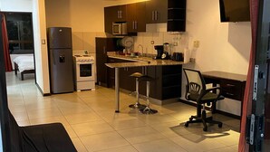 A modern kitchen with a dining area, a refrigerator, microwave, and a ceiling fan. - Beautiful Apartment in Alajuela downtown 5 (Alajuela)