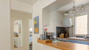 Une cuisine moderne avec un plan de travail en bois, une machine à café et une fenêtre donnant sur un beau paysage.