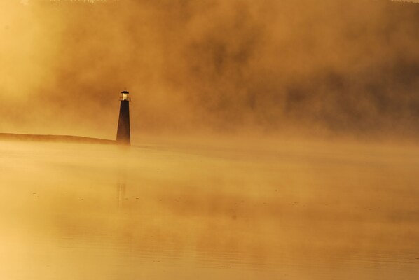 A lighthouse in a foggy setting.