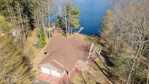 A house with a red roof, a garage, and a driveway. - The Landing on Lake Nebagamon - Includes Pontoon! (Lake Nebagamon)
