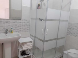 Chuveiro, bidê, toalhas de banho, sabonete