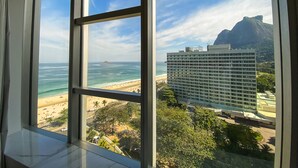 A view from a hotel room window overlooking a beach, a large hotel building, and a mountain. - Hotel Nacional Rio de Janeiro OFICIAL (Rio de Janeiro)