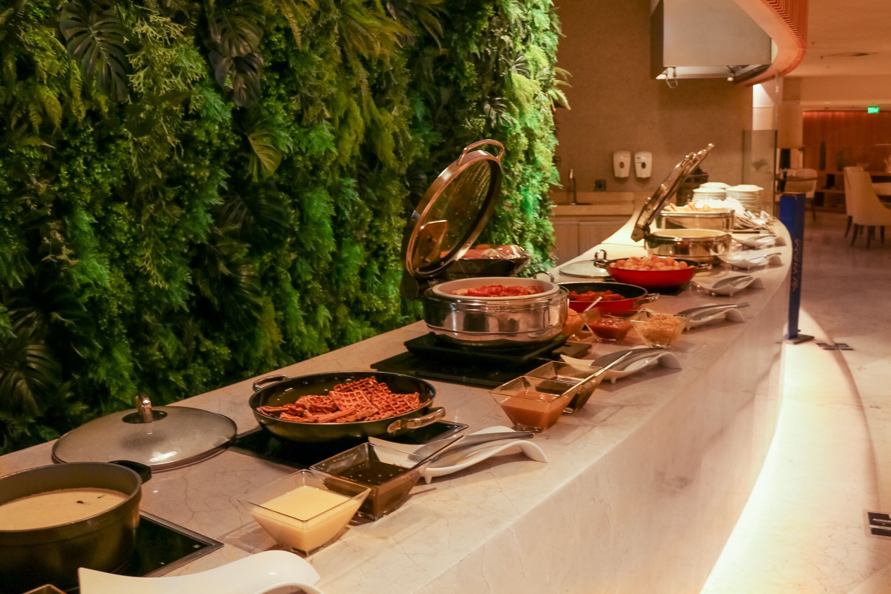 A buffet setup with various food items and serving utensils.
