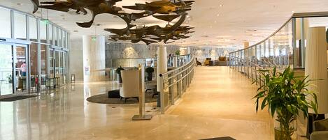 A spacious lobby with a high ceiling, modern furniture, and a central seating area.