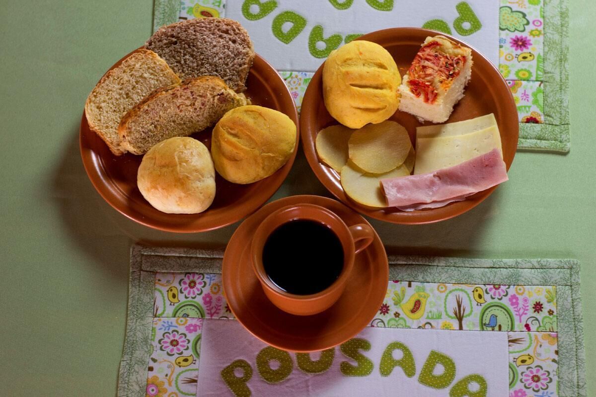Ein Tisch mit Brot, Käse, Schinken und einer Tasse Kaffee.