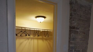 Un pasillo con perchero, suelo de baldosas y pared de ladrillo.