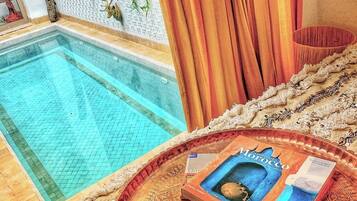 A poolside view with a tray of food and a book.