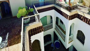 A rooftop with a pool, multiple balconies, and a view of the surrounding buildings. - Riad Lumière (Marrakech)