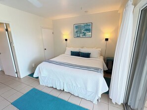 A bedroom with a bed, two bedside lamps, a door, and a window with curtains. - Great family home w/private pool, a/c!! Close to Cruz Bay! (St John)