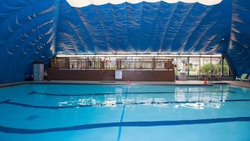 An indoor swimming pool with a blue canopy overhead.