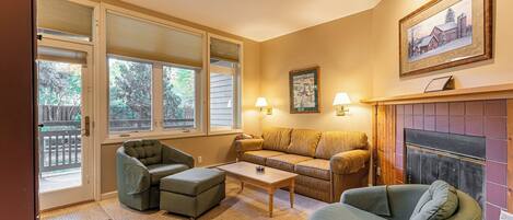 A cozy living room with a fireplace, a sofa, a chair, and a coffee table.