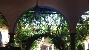 Un pasaje arqueado con una fuente al final, que conduce a un edificio.