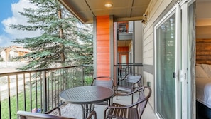 Enjoy a balcony with a round table and four chairs, offering a view of the surrounding natural landscape.