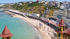 Uma cidade costeira com uma praia de areia, um calçadão e edifícios residenciais.