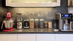 A kitchen with a modern design, including a stand mixer, a coffee machine, and various storage containers. - Stylish 168 m² loft in the heart of Düsseldorf (Stadtbezirk 3)