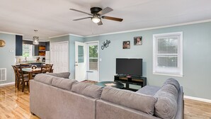 A living room with a sectional sofa, a dining table with chairs, a TV, and a ceiling fan. - Down town Travelers rest walking to swamp rabbit bike trail  (Travelers Rest)