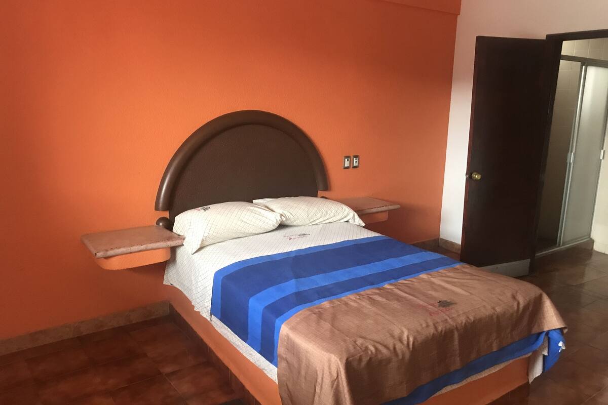 A bed with a headboard, a bedside table, and a nightstand.