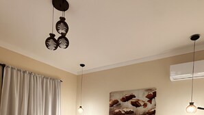 A modern bedroom with a large bed, bedside tables, a bench, and a ceiling light fixture. - Pousada Villa Zena (Porto Seguro)