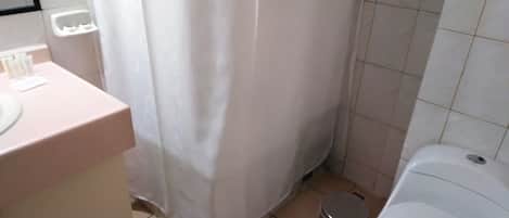 A bathroom with a toilet, a sink, and a shower curtain.