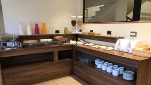 A buffet setup with various food items and condiments. - Hotel Turismo Temuco (Temuco)