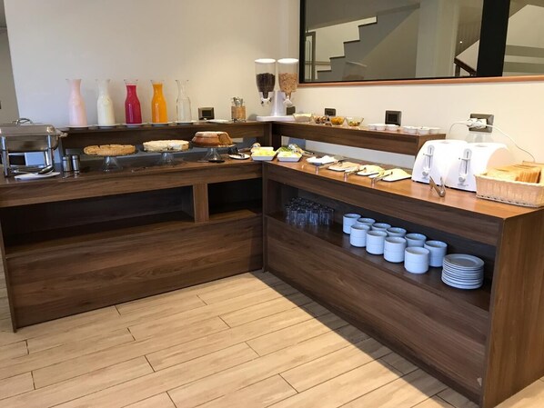 A buffet setup with various food items and condiments.