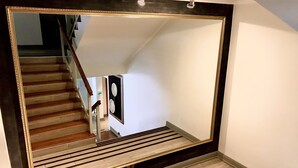 A staircase with a wooden handrail and a black-framed mirror reflecting the stairs. - Hotel Turismo Temuco (Temuco)