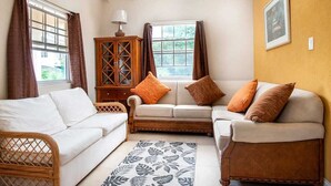 A cozy living room with a sofa set, a wooden cabinet, and a patterned rug.