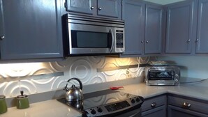 A kitchen with a microwave, toaster, kettle, and stove. - Peaceful Lakefront Getaway, Stunning Sunsets & Waterfront Relaxation (Keystone Heights)